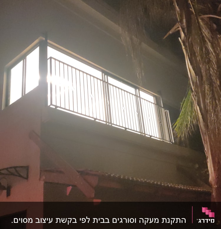 מעקה מתכת מואר במרפסת בלילה